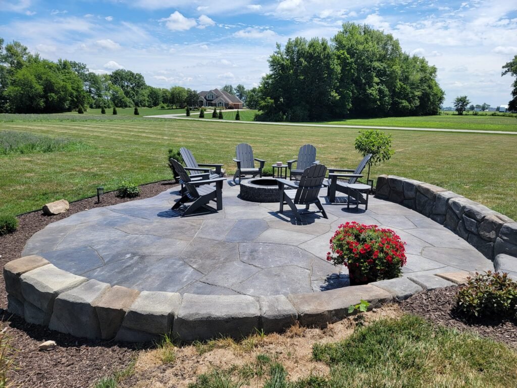 Circular stamped concrete patio with a fire pit and curved seating wall in Fort Wayne, Indiana.