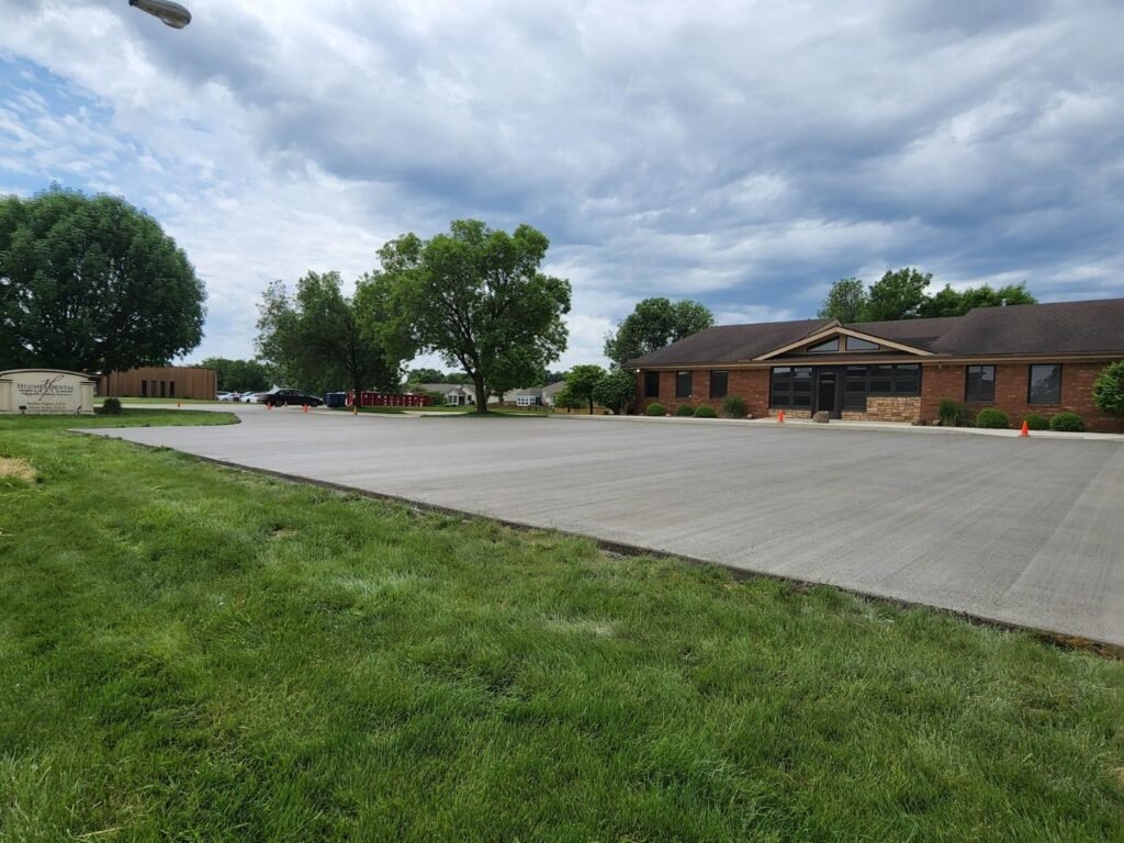 Broom-finished commercial concrete parking lot outside a brick office in Columbia City, Indiana.