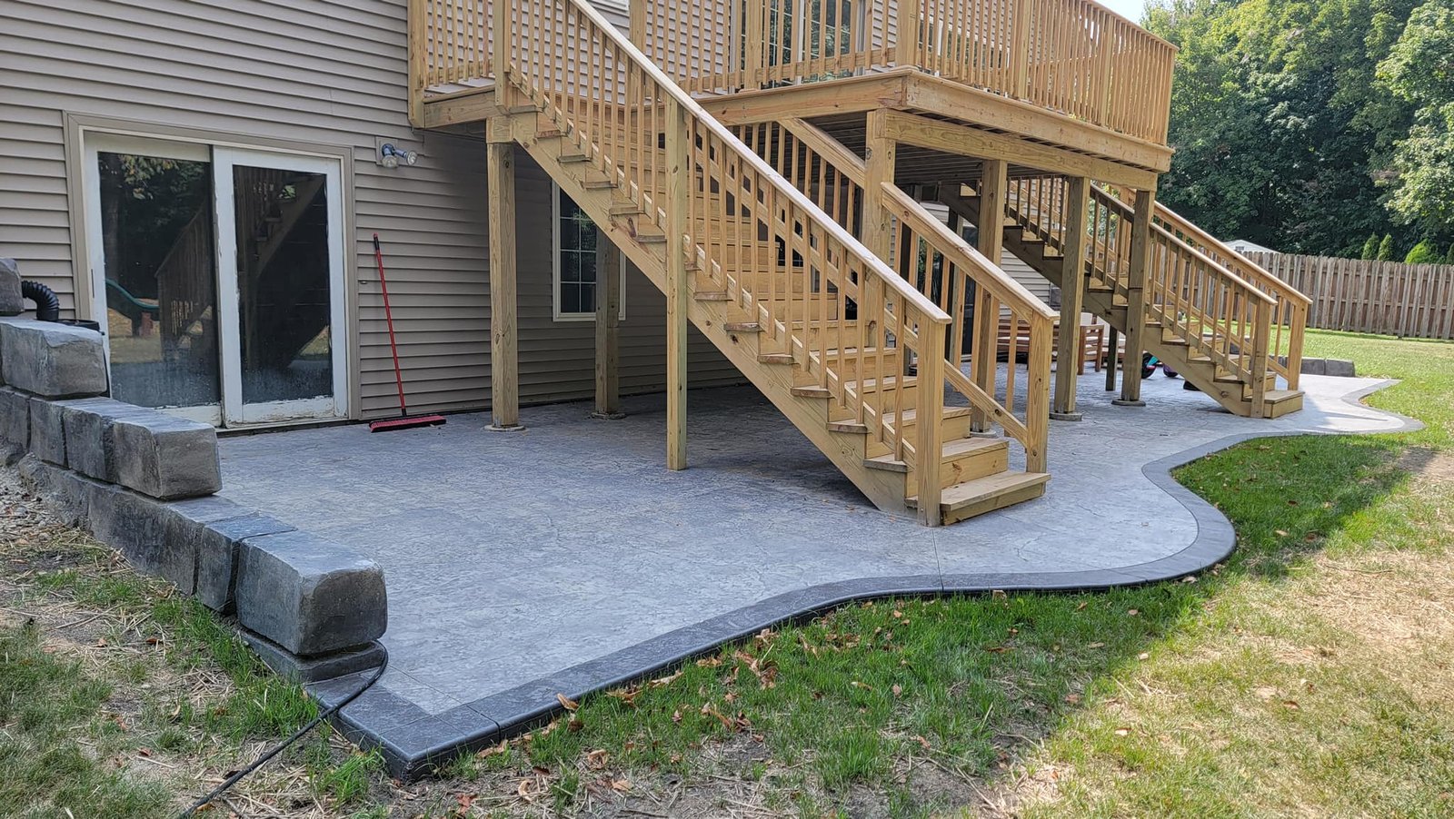 Concrete patio with wooden stairs. concrete contractor in Ligonier