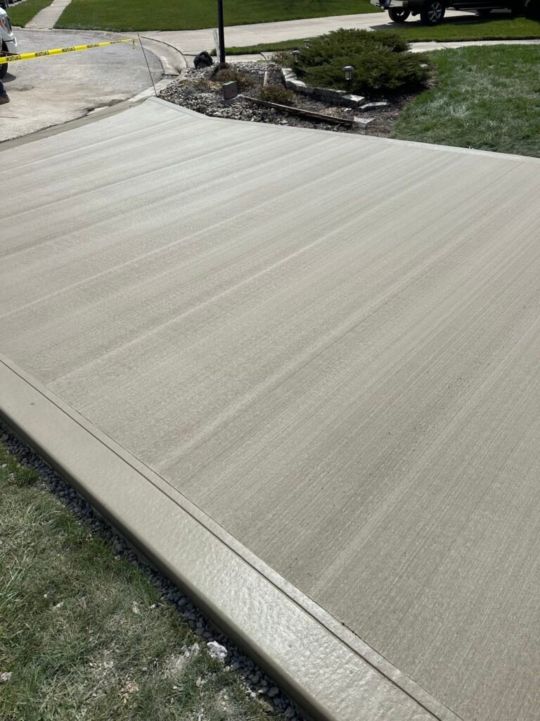 Broom-finished concrete driveway curing in Churubusco, Indiana.