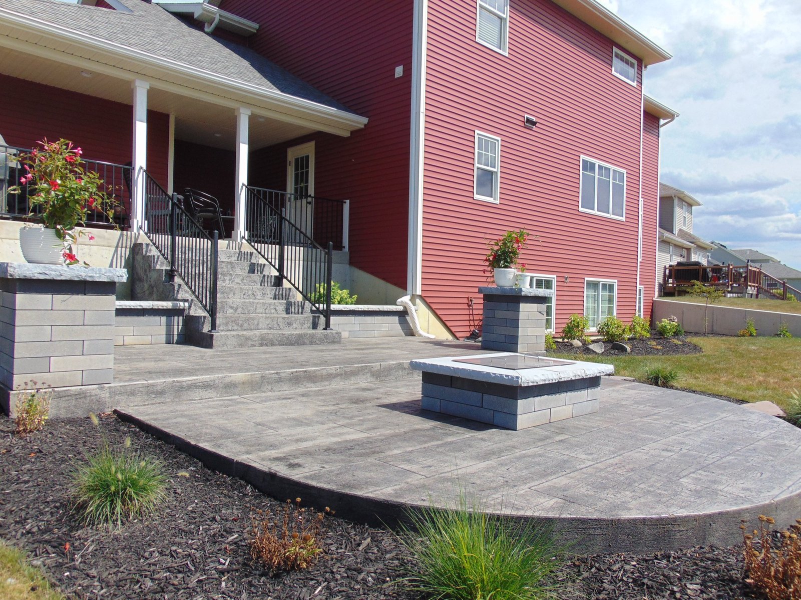 Stamped concrete patio with a wood pattern and a square fire pit. Stamped concrete in Berne.