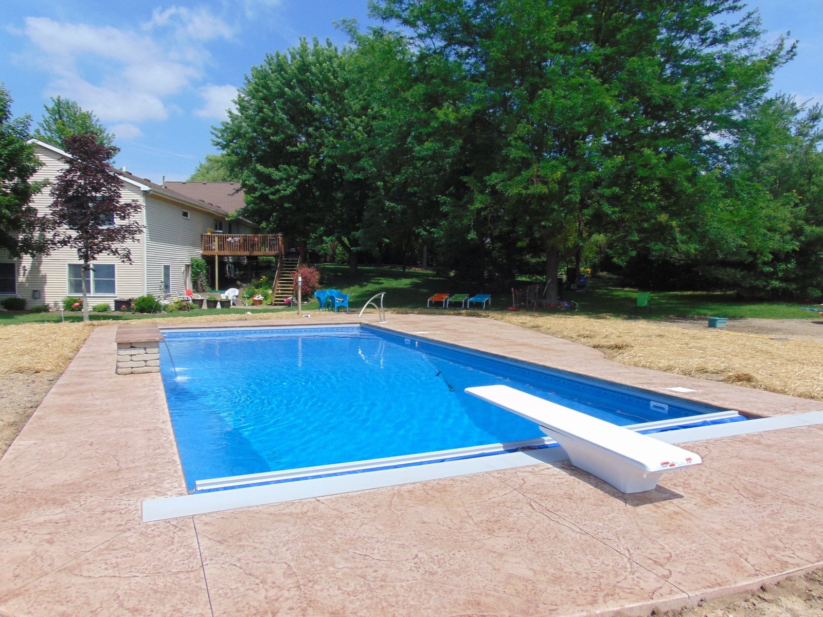 Stamped concrete in LaGrange. Red stamped concrete surrounding a pool with a diving board.