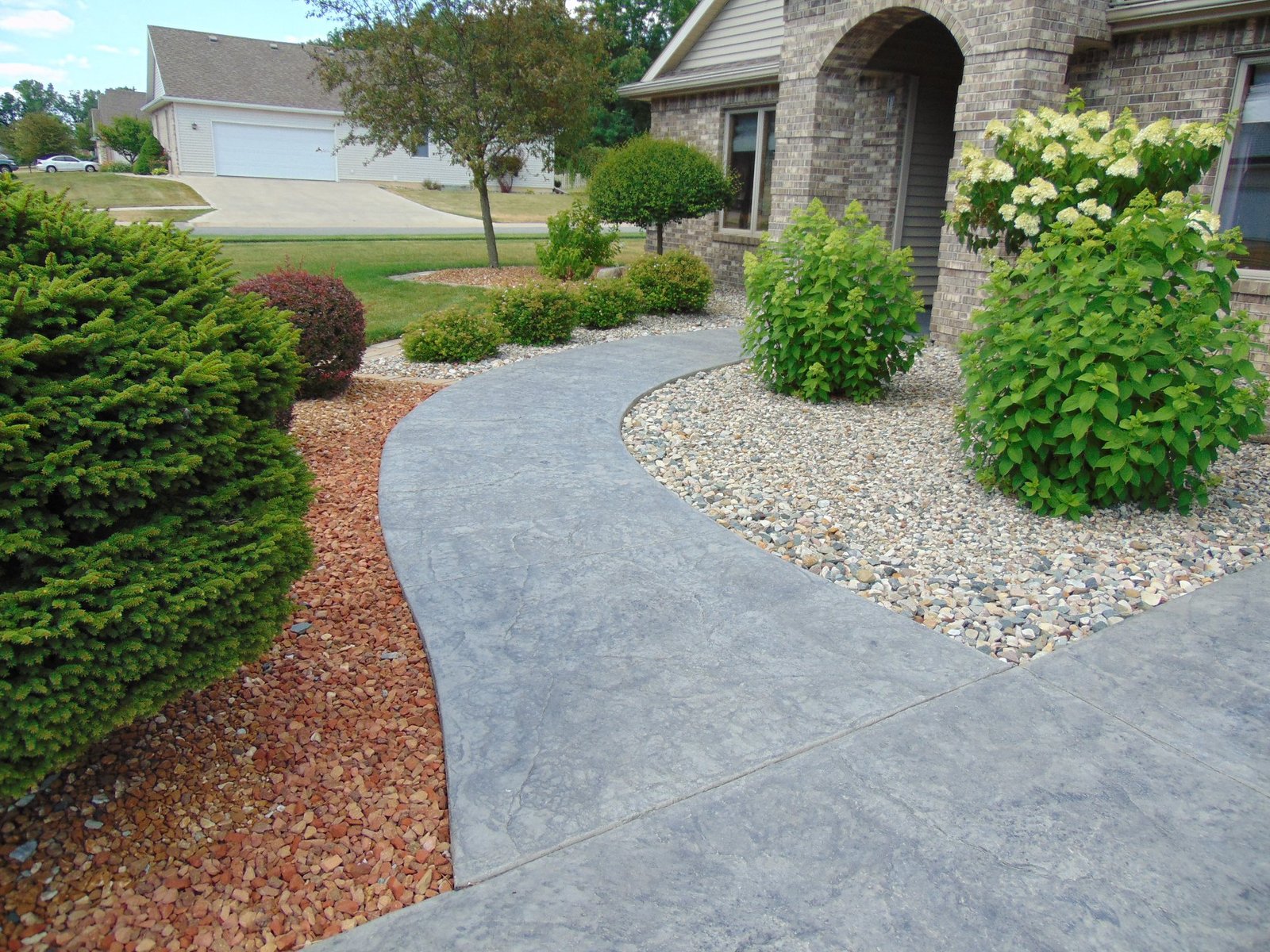Curved stamped gray concrete walkway