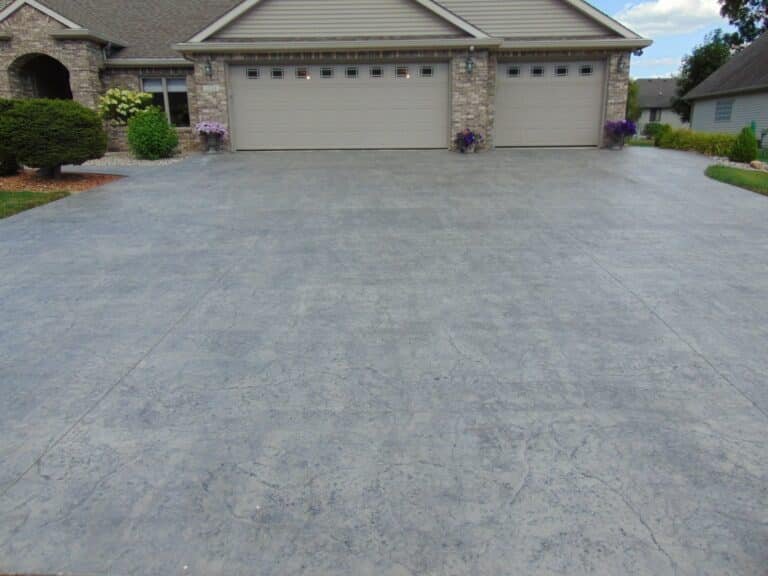 Broom-finished three-car concrete driveway replacement in Fort Wayne, Indiana.