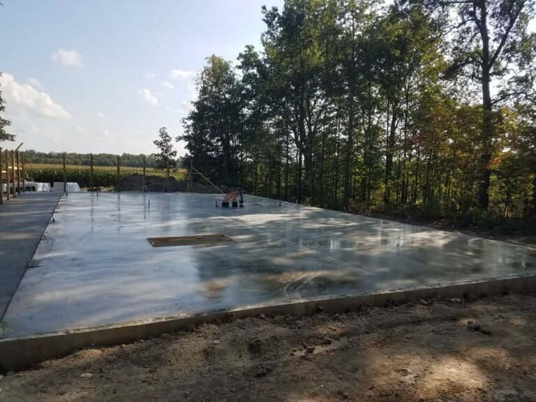 Freshly poured concrete foundation slab on a wooded property near Huntertown, Indiana.