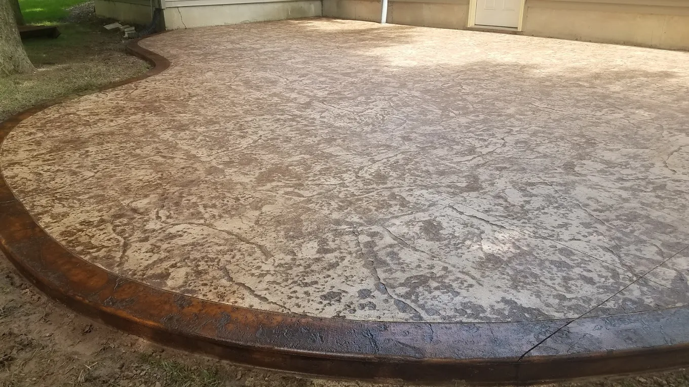 Brown stamped concrete patio with textured stone pattern and rounded edge detail. Stamped concrete in Auburn.