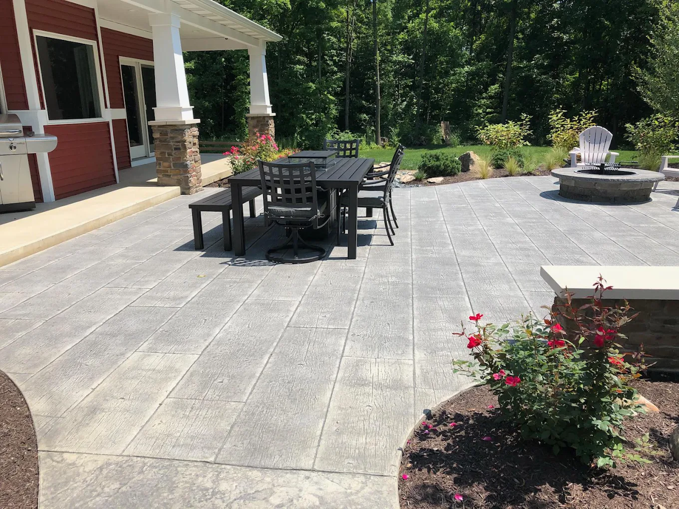 Spacious stamped concrete patio with outdoor dining area, fire pit, and surrounding garden beds. Stamped concrete in Decatur. Stamped concrete in Middlebury