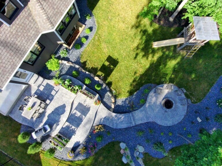 Aerial view of a multi-level concrete pool patio with steps and landscaping