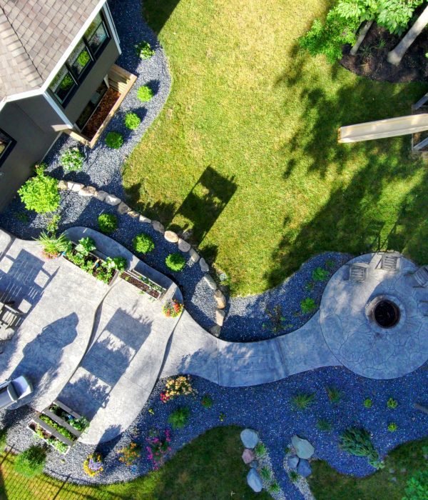 Bird’s-eye view of a custom multi-level poolside concrete patio with integrated landscaping, stairs, and lounge areas.